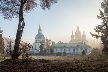 Orthodox church in the morning fog at dawn in the middle of the park