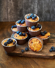 Blueberry muffin. Decoration with blueberries. Wooden background. Side view. Purple flowers