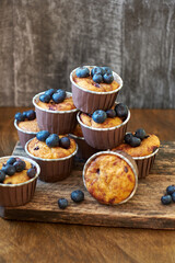 Blueberry muffin. Decoration with blueberries. Wooden background. Side view. Purple flowers