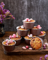 Cupcakes decorated with Easter chocolate eggs. Wooden background. Side view.