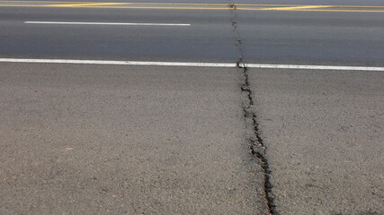 Cracked asphalt road.  Large asphalt roads have cracks on bridges or from subsidence with copied areas. Selective focus