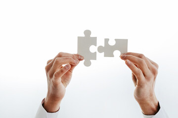 cropped image of a businessman showing puzzle pieces.