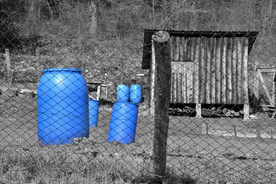 Conteneur bleu, réservoirs bleus, réserve d'eau, bidons bleus dans un champ, bidons bleus pour l'eau dans le potager
