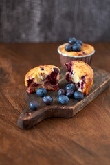 Blueberry muffin. Decoration with blueberries. Wooden background. Side view.