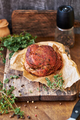 Baked meat with thyme on a wooden board. Wooden background. Rustic style. Side view. Beef, pork.