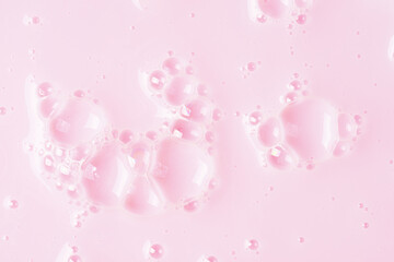 Foamed surface of pink liquid soap, small bubbles, closeup