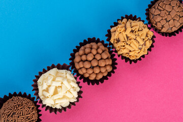 Typical brazilian brigadeiros, various flavors over colorful background with room for text