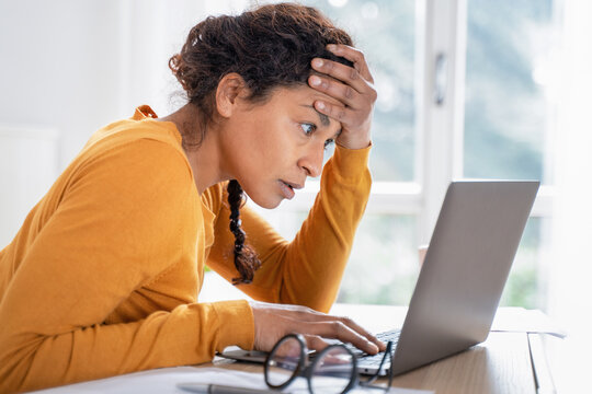 Young woman feeling stressed while looking bank account online