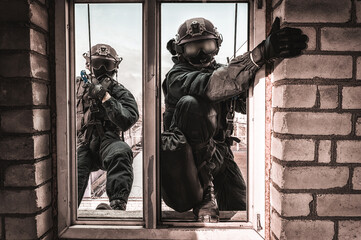 Group of special forces fighters storm the building through the window. Training sessions of the...