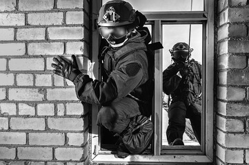 Group of special forces fighters storm the building through the window. Training sessions of the...