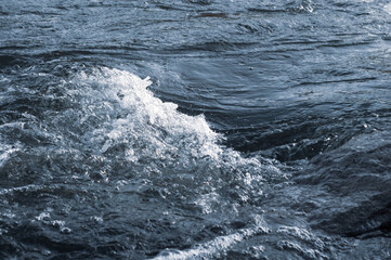 Background, top view, rapid flow river with dark blue water and white foam waves