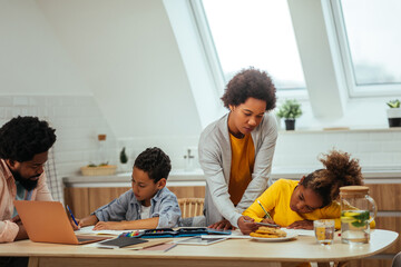 Obraz premium Afro parents helping their children with his homework