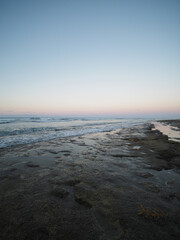 Fototapeta na wymiar Rocks beach at evening sunset. Atlantic Ocean coast in Dominican Republic.
