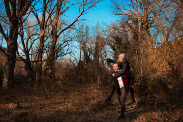 Naklejka premium Young couple on a trip during Coronavirus pandemic. Girlfriend doing piggyback of the boyfriend having fun during a trip while they wear face mask. Concept travel safe during Covid-19. 