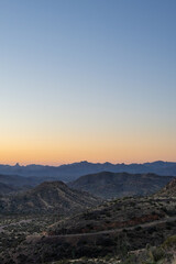 Orange and blue Arizona sunset behind mountains 