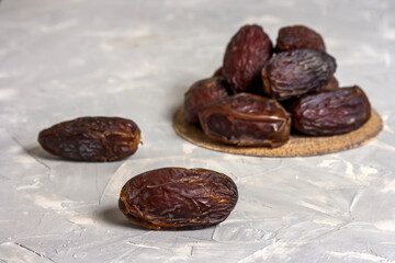 Heap of ripe dates on light background with copy space