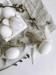 Stylish rural Easter flat lay. Natural easter eggs, feathers, willow branches on rustic aged table