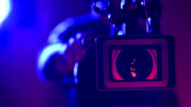 Telephoto Digital Film Camera Lens Close Up and Industry Camera Operator Behind the Equipment.