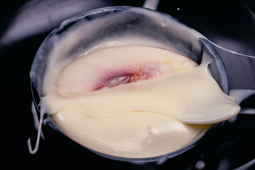 close-up of peach in high speed on yogurt with dark background