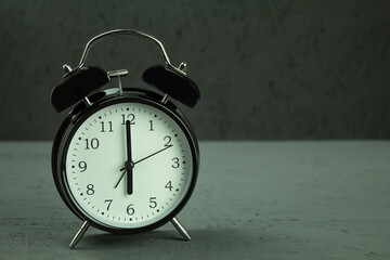 Clock in vintage style, 6 am, on a dark wooden background