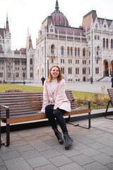 Obraz premium Tourist - a girl travels around Europe. Travel to Hungary, European tour.A girl near the Hungarian parliament.