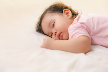 Obraz na płótnie Canvas Adorable cute toddler or baby girl sleeping on bed at night with sweet dream in bedroom Lovely child get deep sleep and get relax and happy during lying down on bed Little infant girl get good sleep