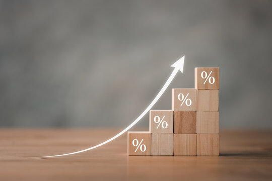 Interest Rate Financial And Mortgage Rates Concept. Wooden Blocks With Icon Percentage Symbol And Arrow Pointing Up. The Economy Is Improving.