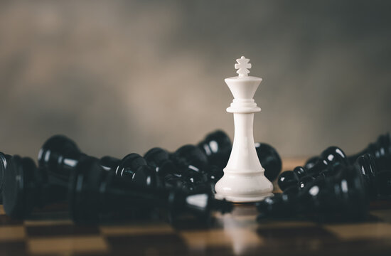 White Chess King among lying down black pawns on chessboard, chess board game for ideas and competition and strategy, Planning and Decision concept.