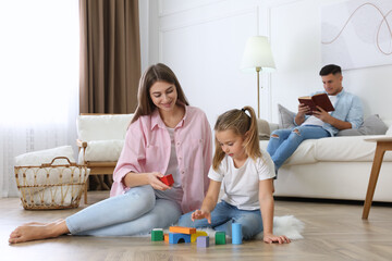 Mother playing with her daughter at home. Floor heating concept