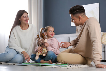 Happy family with little daughter spending time together at home. Floor heating concept