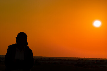 Man in Desert Portrait with Sunset in Background