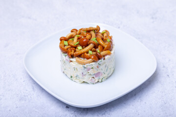 Salad with mushrooms (honey fungus), ham, potatoes, cheese and mayonnaise. Traditional Russian...