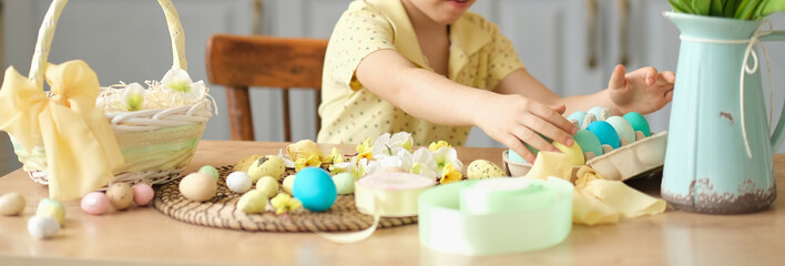 banner unrecognizable little boy puts colored eggs in a wicker Easter basket. easter preparation concept
