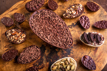 Stuffed chocolate easter egg with grated chocolate on the top and lots of mini stuffed easter eggs all around it on a tree trunk.