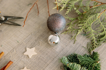 Composition from elements of winter decor. Decorations, spruce and thuja branches, balls on the table. The creative process of creating a design.