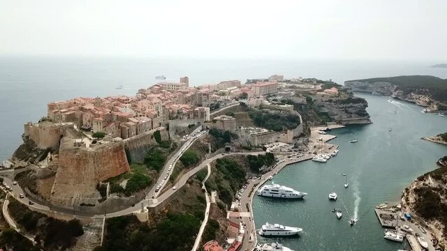 Drone flies over the port and town of Bonifacio on the island of Corsica with the cliffs in the background, France.