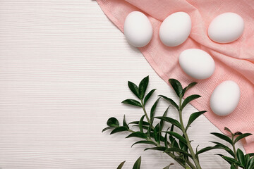 Fototapeta na wymiar White eggs on a pink tablecloth. Tabletop texture. Green leaves. Easter plot.