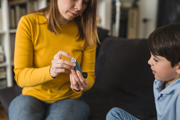 mother explaining to her son how to use asthma pump