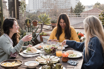 Happy multiracial friends eating breakfast in restaurant outdoors during coronavirus outbreak -...