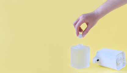 female hand holding a refill tablet for soap dispencer. automatic foam making device. eco friendly waste reduce cleaning. hand disinfecting with refillable solution