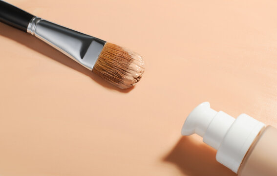 Natural makeup brush for foundation,with a bottle of beige fluid foundation, Makeup foundation background, Fluid foundation base for nude skin