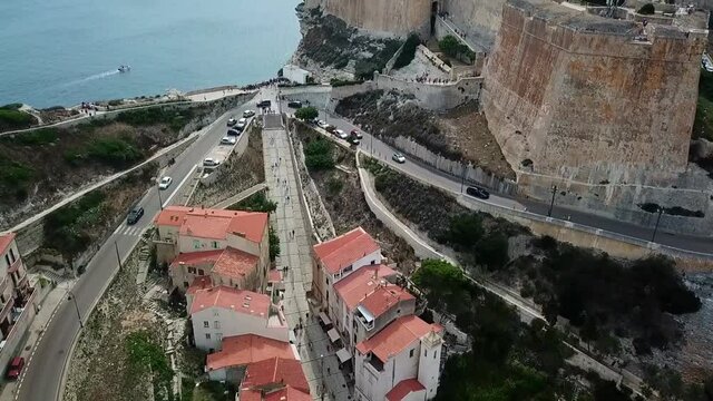 Drone flies over the Citadelle and the town of Bonifacio on the island of Corsica built on cliffs, France.