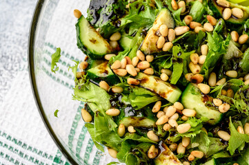 Healthy food concept: green salad with cucumbers, mint, pine nuts and balsamic. Selective focus....