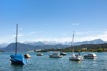 Panorama of Lake Lucerne, yachts in the water, view on Alps mountains, summer day. Switzerland