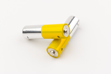 Photo of gray-yellow alkaline AA batteries on white background. Recycling of rechargeable NiMH...