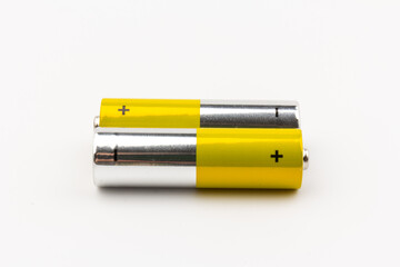 Photo of gray-yellow alkaline AA batteries on white background. Recycling of rechargeable NiMH...