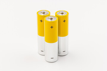 Photo of gray-yellow alkaline AA batteries on white background. Recycling of rechargeable NiMH batteries. The most popular size of accumulators. Copy space.