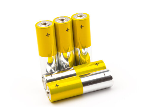 Photo of gray-yellow alkaline AA batteries on white background. Recycling of rechargeable NiMH batteries. The most popular size of accumulators. Copy space.