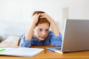 Photo a boy pupil in front of a laptop monitor during an online lesson. Online education concept.