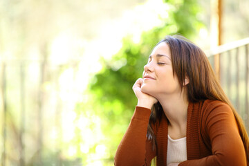 Woman relaxing with closed eyes in a garden at home